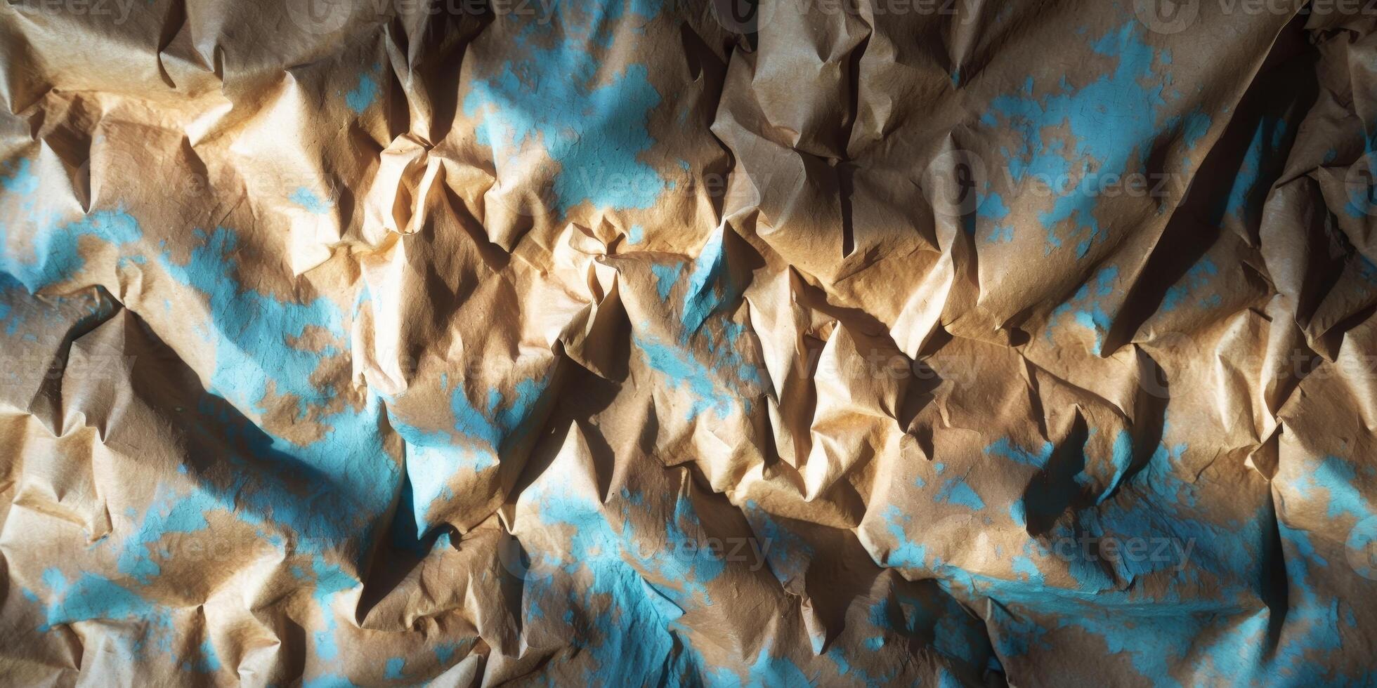 Distressed crumpled paper texture with brown and blue hues creating a vintage backdrop with intricate lighting and shadows on a flat surface photo