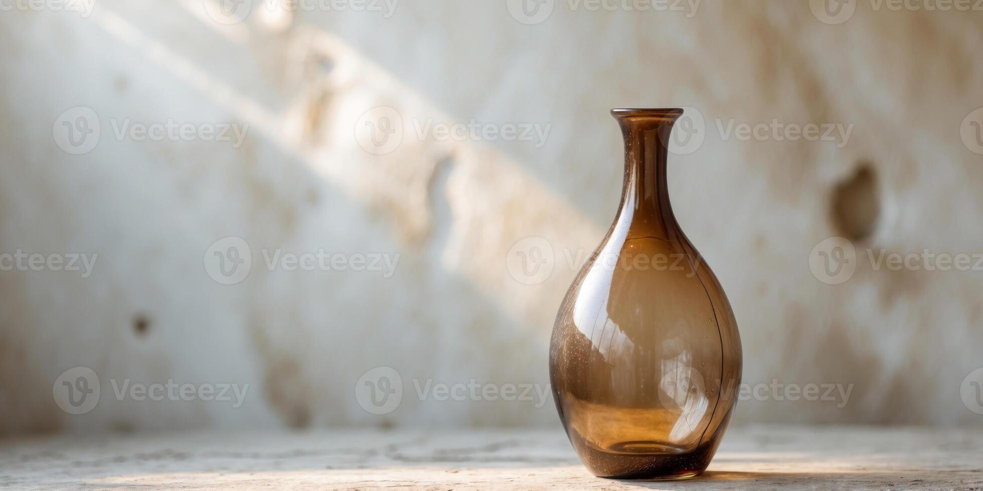 A decorative brown glass bottle sits on a textured surface photo