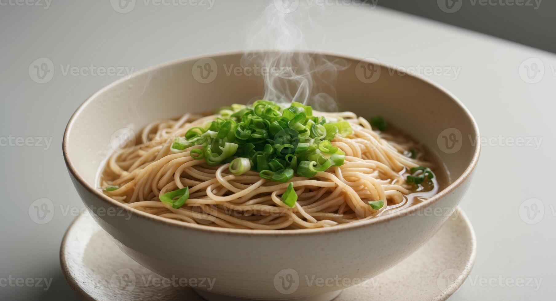 Steaming Bowl of Noodles Topped with Fresh Chopped Green Onions photo