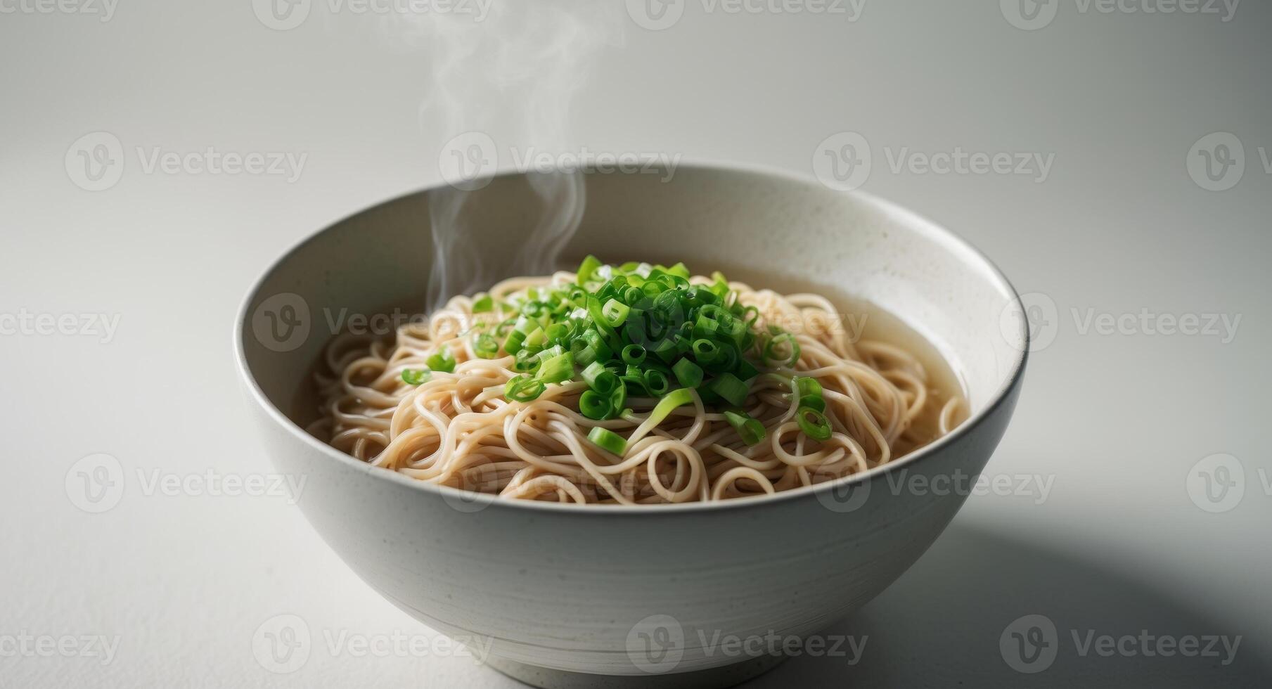 Steaming Bowl of Noodles Topped with Fresh Chopped Green Onions. photo