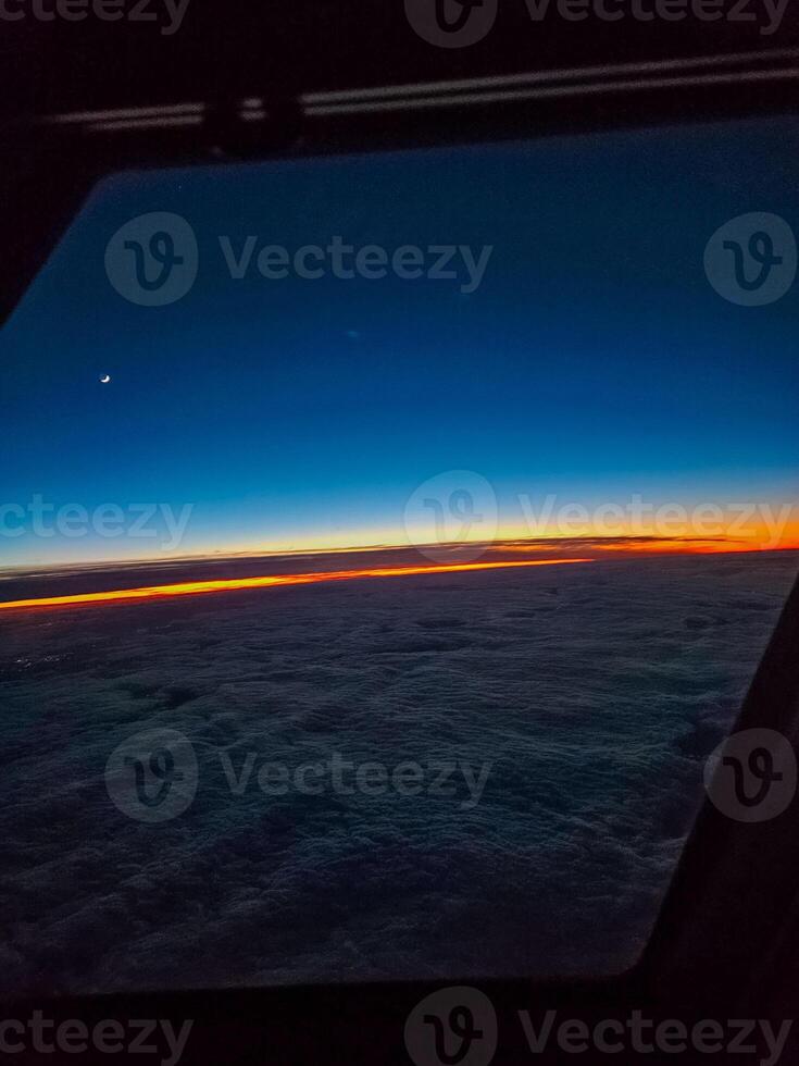 Cockpit view at sunrise. horizon, soft clouds, crescent moon frame the window. High quality photo
