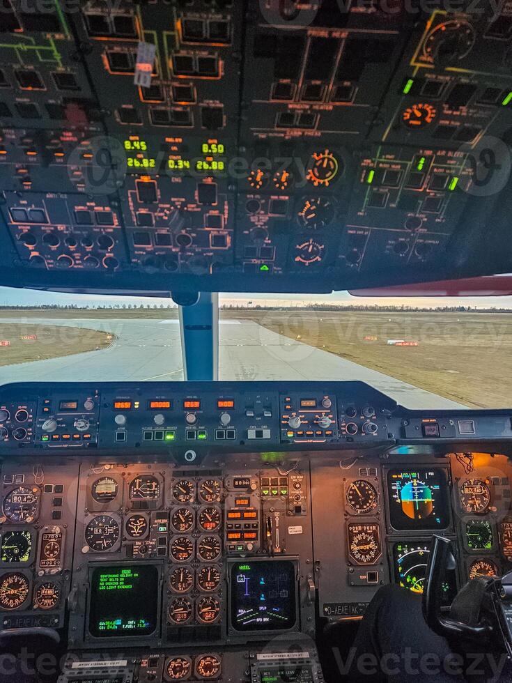 Illuminated cockpit view of an aircraft ready for takeoff at sunrise. High quality photo