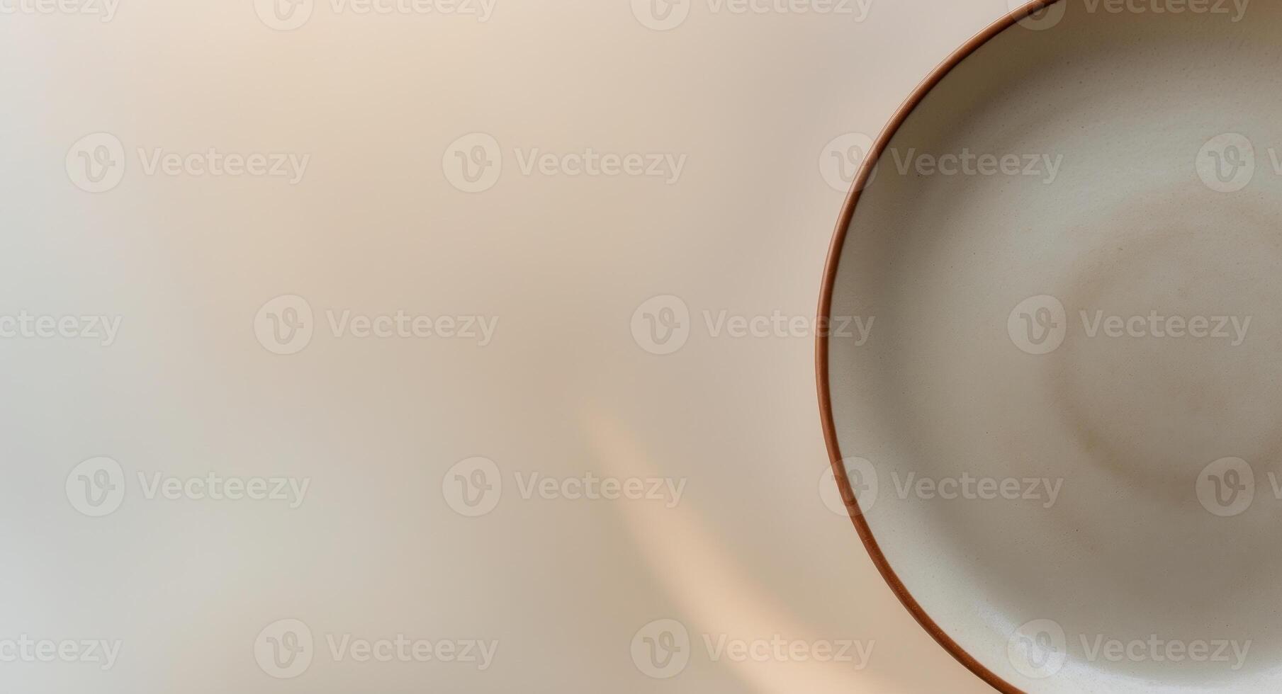 a close up of a plate with a brown rim on a beige background photo
