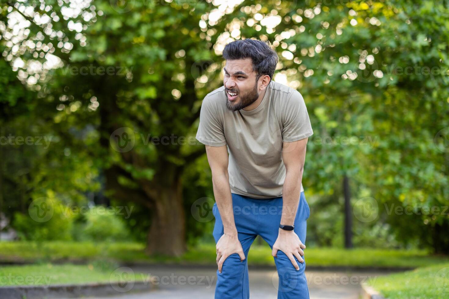 Man showing determination and effort while engaged in active physical exercises in park. Captures essence of outdoor fitness and healthy lifestyle in natural setting, emphasizing physical wellness. photo