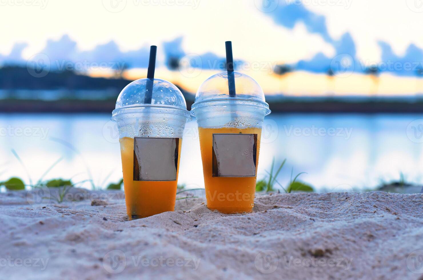 Two plastic cups with iced tea take away against the sea photo