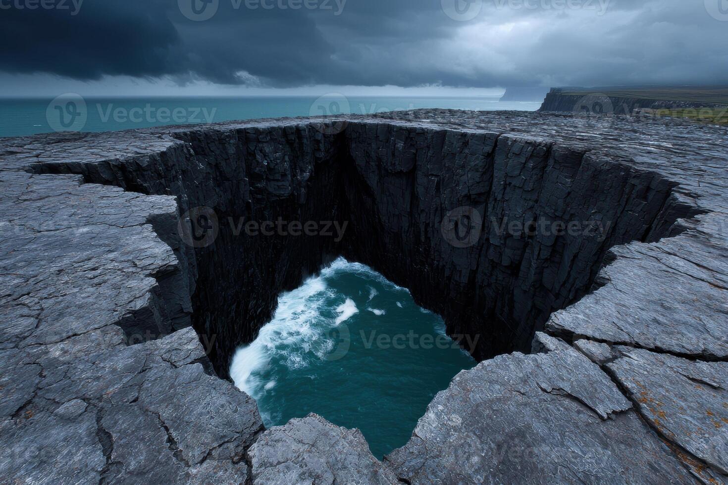 Dramatic coastal cliffs with ocean waves crashing into a deep crevice photo