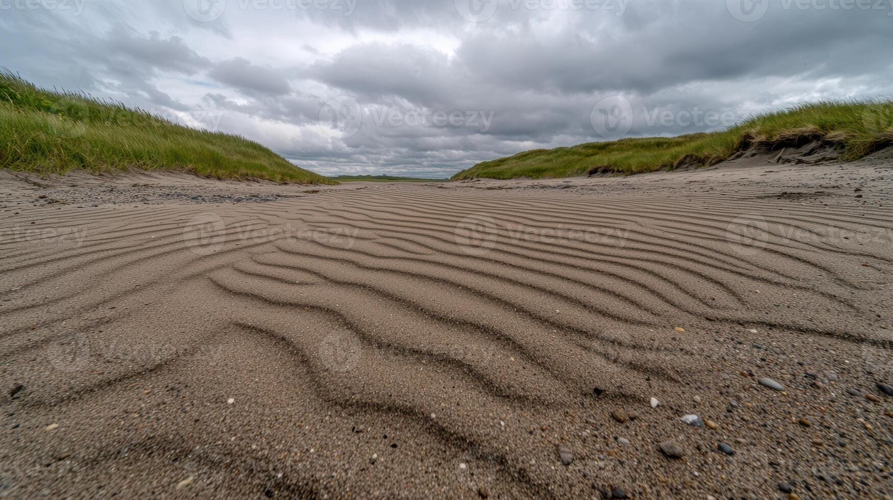 Windswept sand dunes on a beach with cloudy sky photo