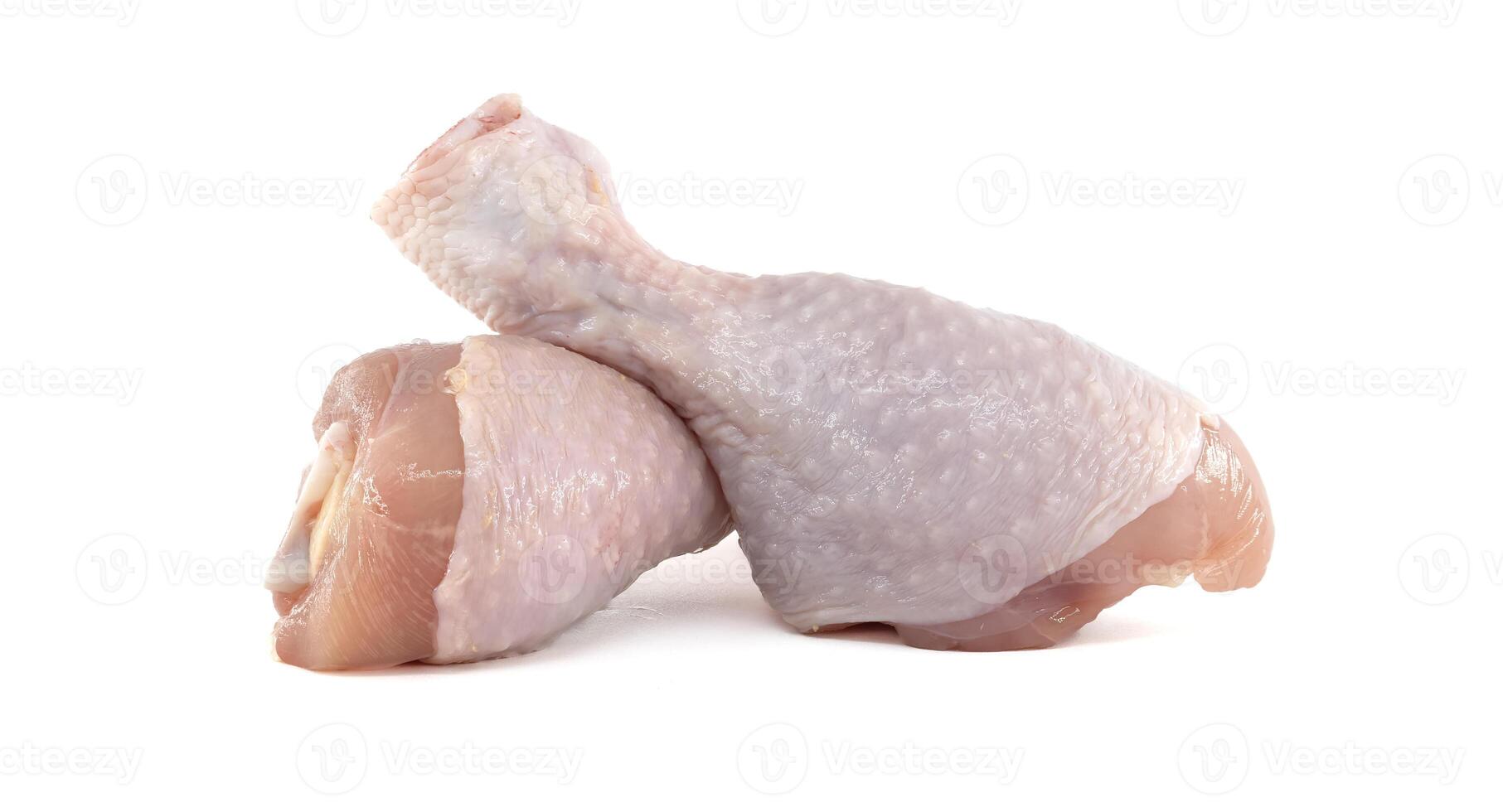 Two raw chicken drumsticks resting on a white background photo