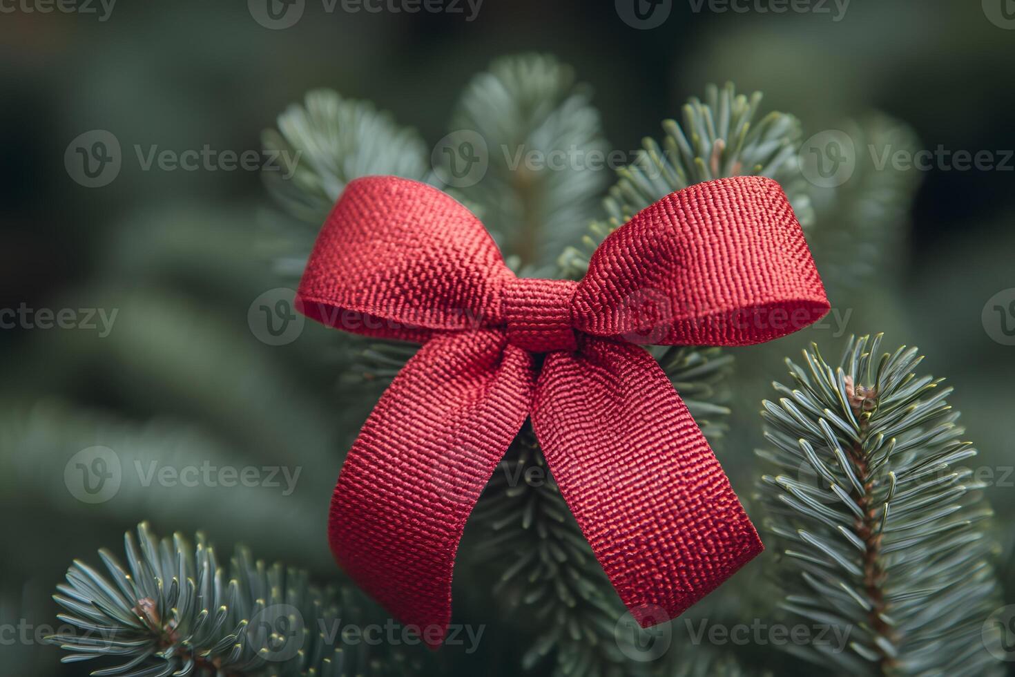 Red Bow on Evergreen Branch for Christmas Decorating and Holiday Cheer photo
