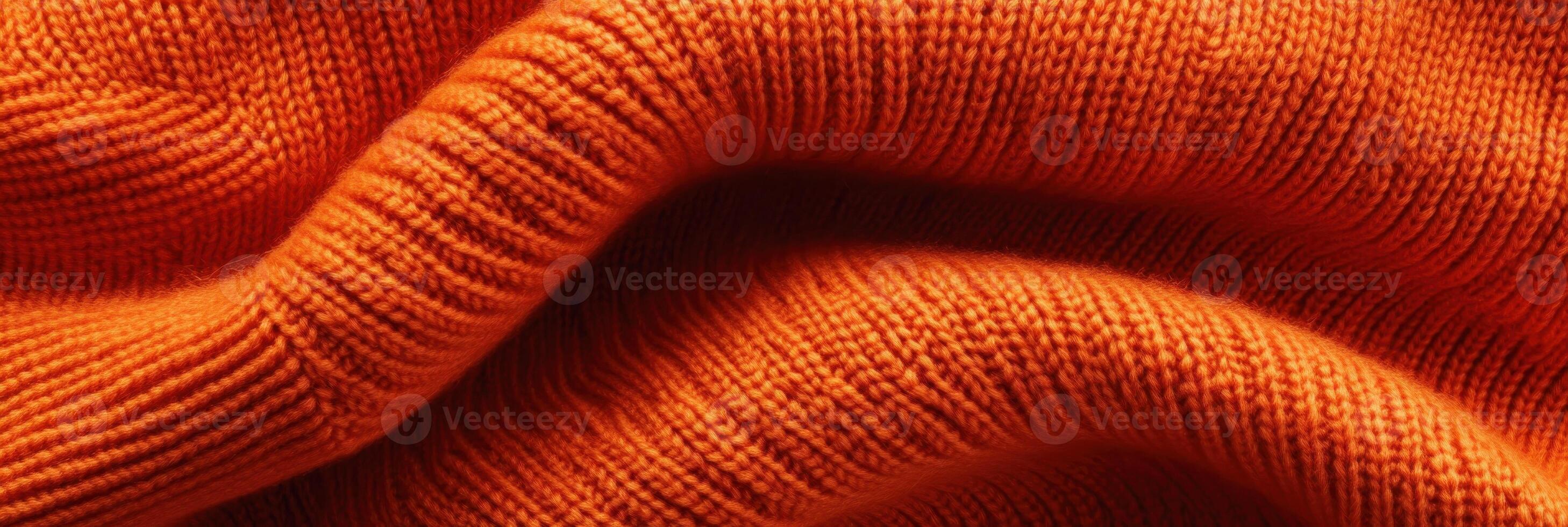 Close-up of orange knitted fabric texture featuring intricate patterns photo