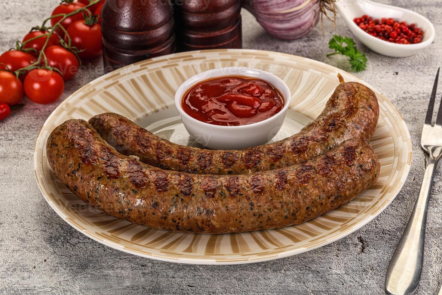 Two sausages on a plate with tomato sauce photo