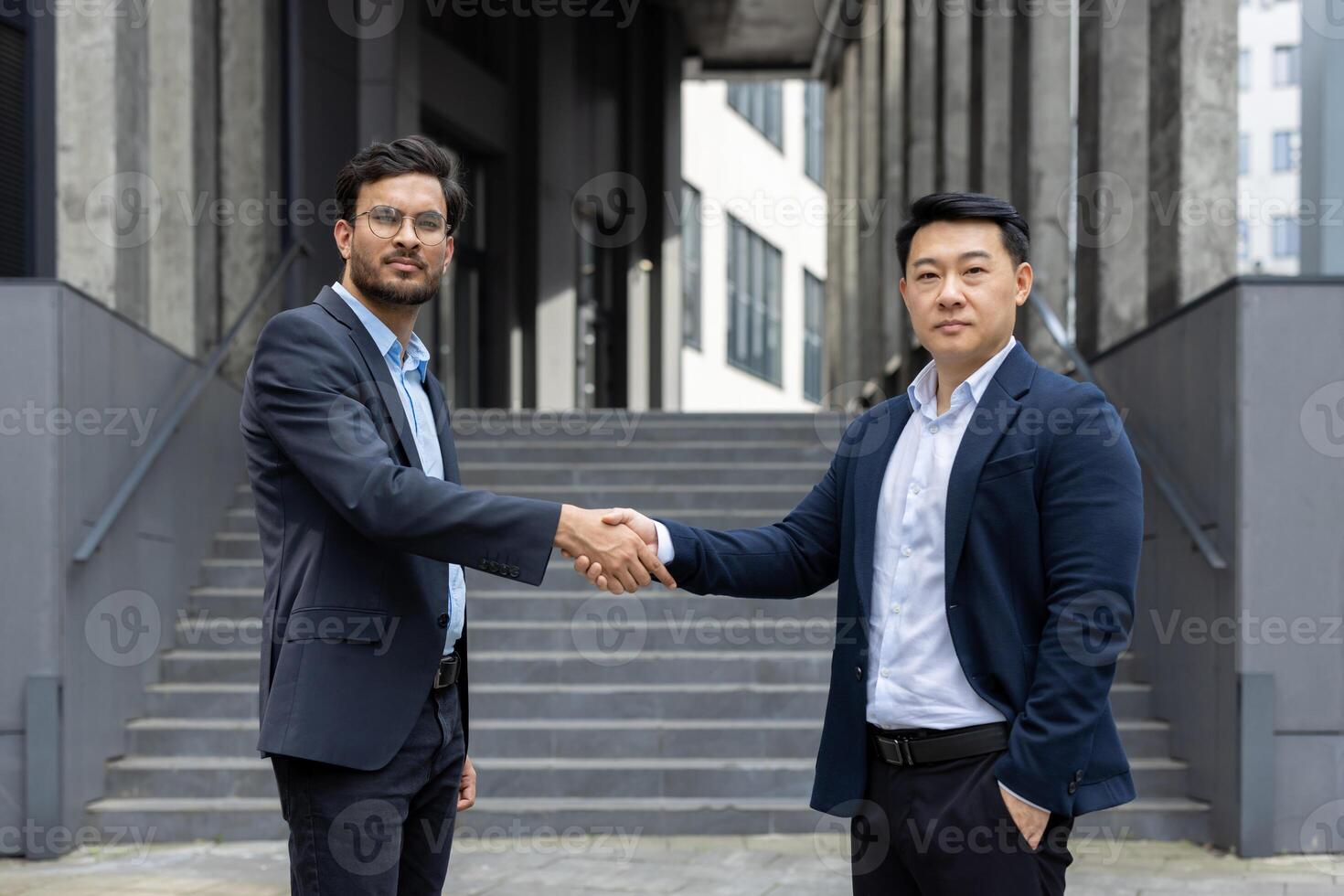 Two professionals engage in a business handshake outdoors, signifying agreement and collaboration. The image captures a moment of professional partnership in a contemporary setting photo