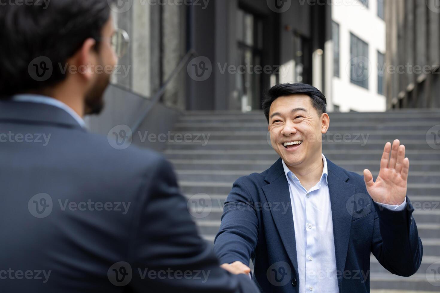 Two business professionals exchanging a friendly handshake and warm smile an outdoor urban setting. The scene captures the essence of professional courtesy, networking, and successful collaboration photo