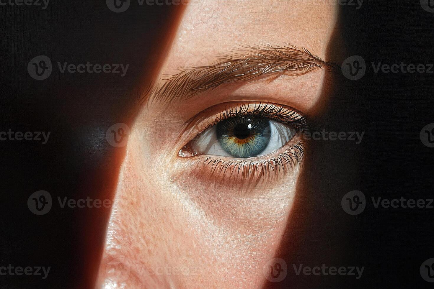 A striking close-up where intense blue-green eyes meet the viewer. The face is partially obscured by shadows, creating a sense of intrigue and depth in the expression photo
