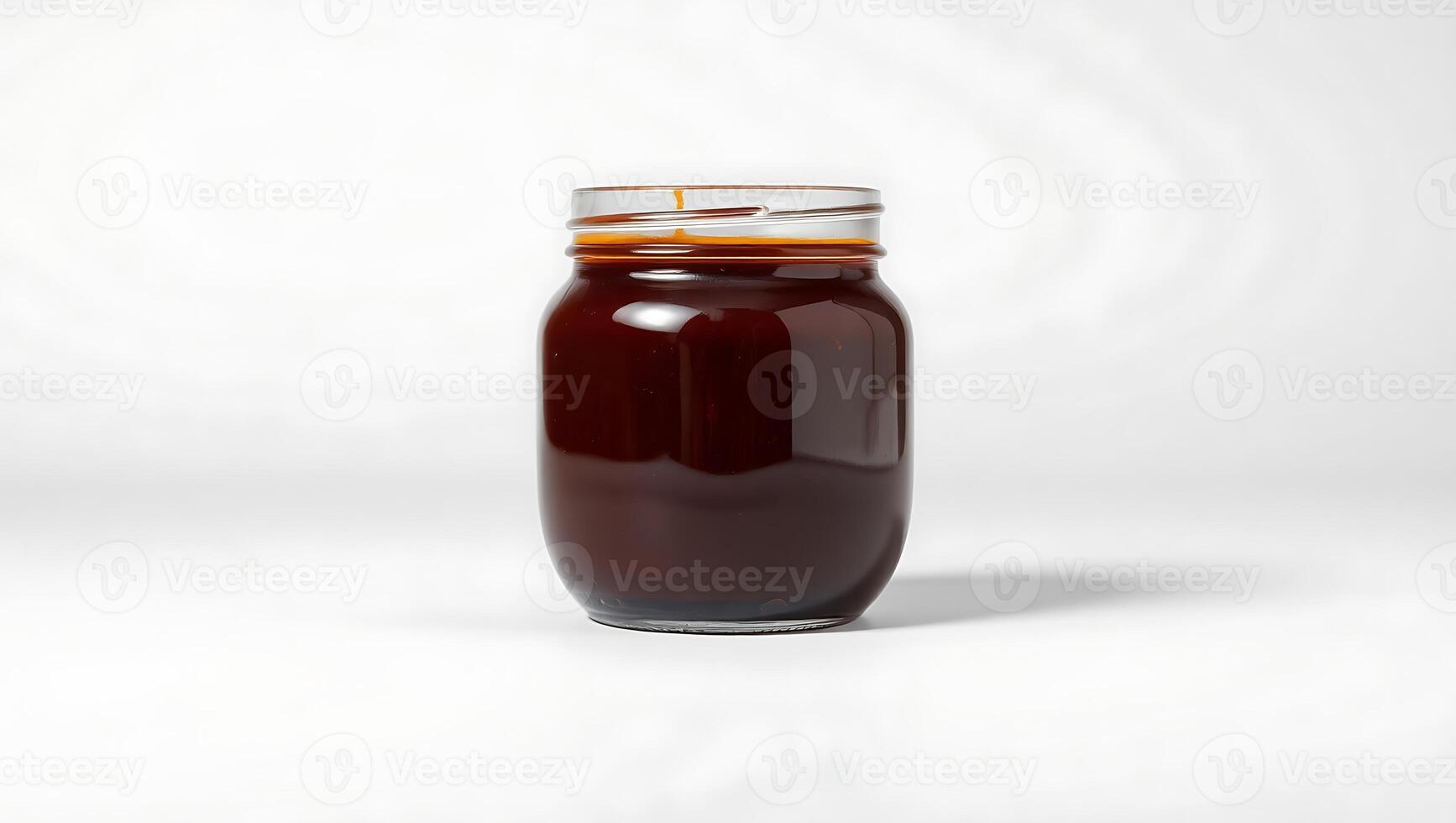 Dark liquid in a clear glass jar on a simple background photo
