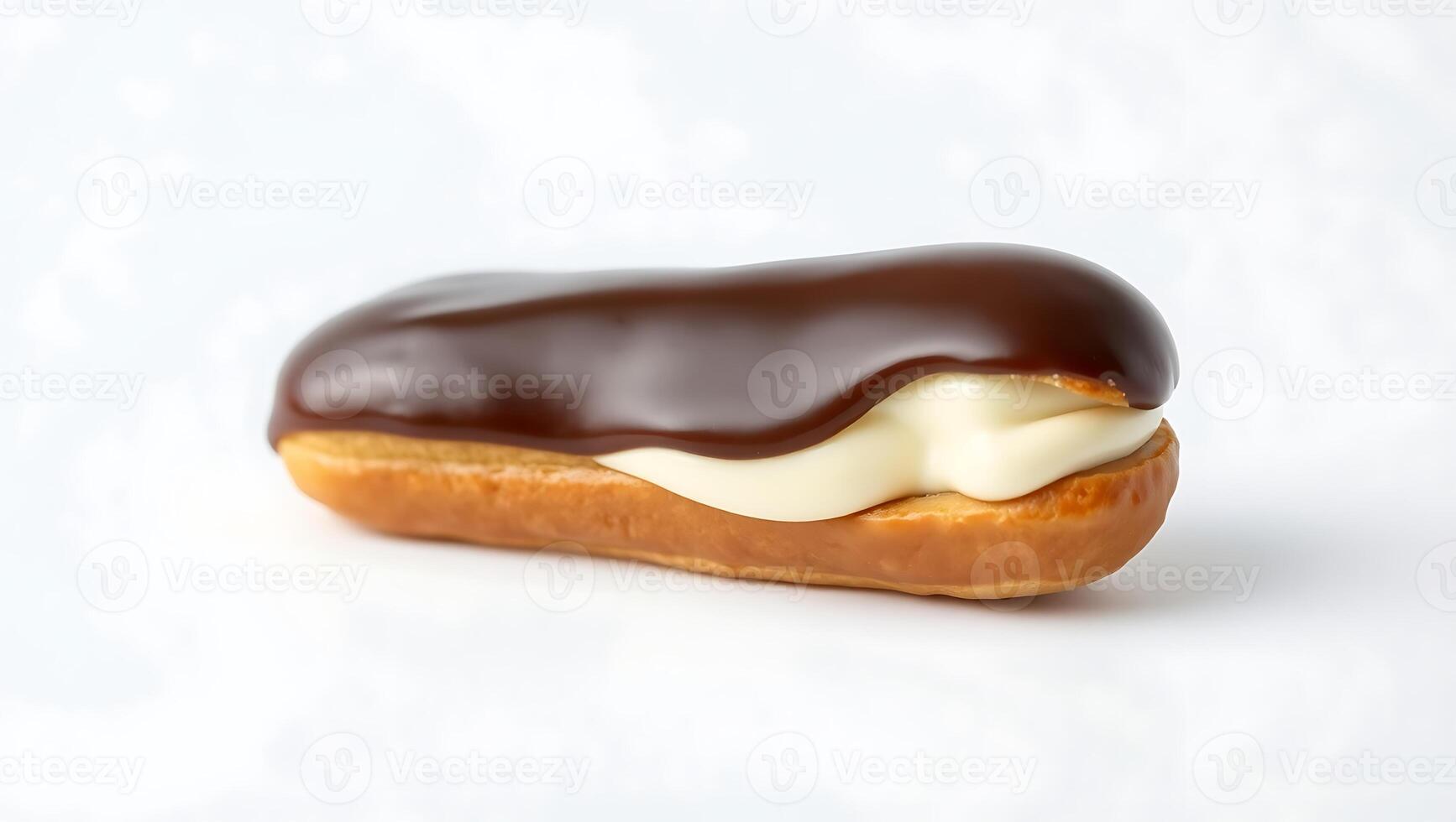 Chocolate-covered eclair with creamy filling on a plain surface photo