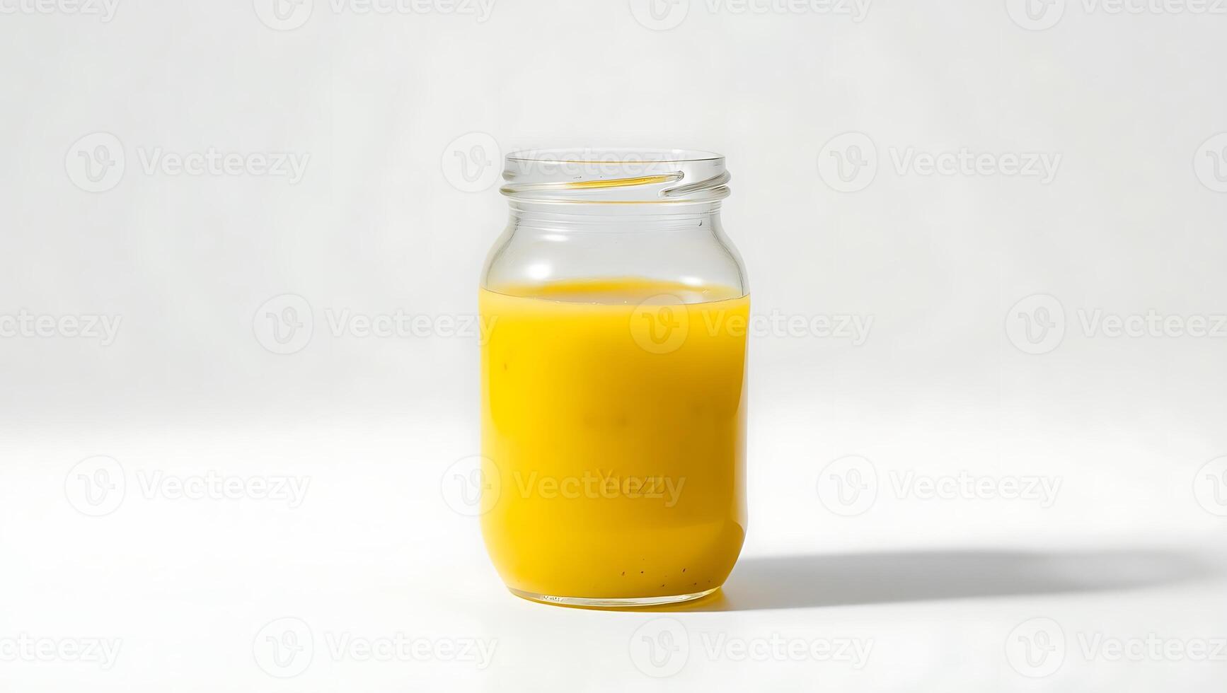 Fresh orange juice in a clear glass jar on a light backdrop photo