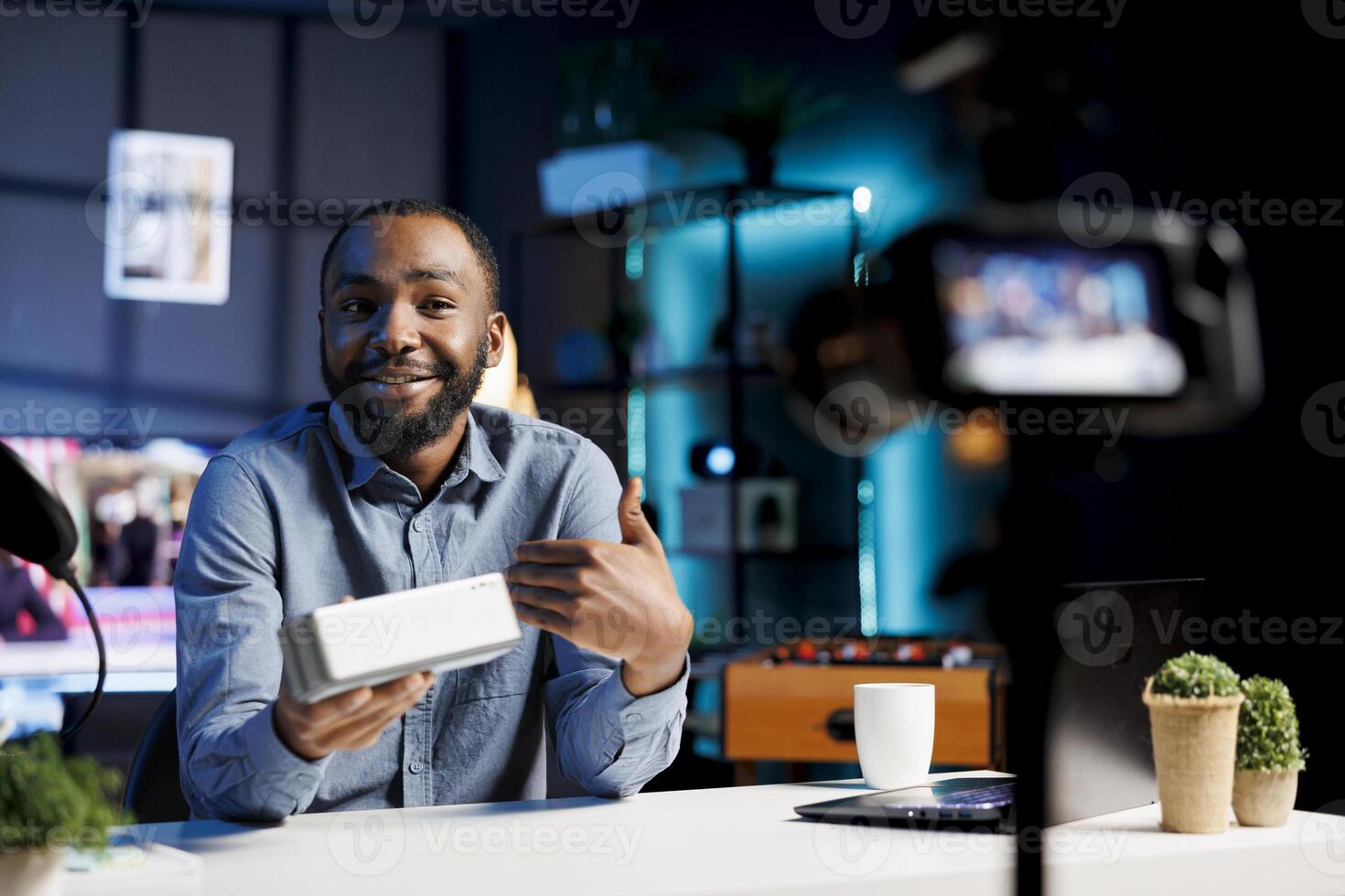 African american internet show host using professional camera and microphone to film content about best stereo audio devices of the year. Tech engineer recording Bluetooth speaker review photo
