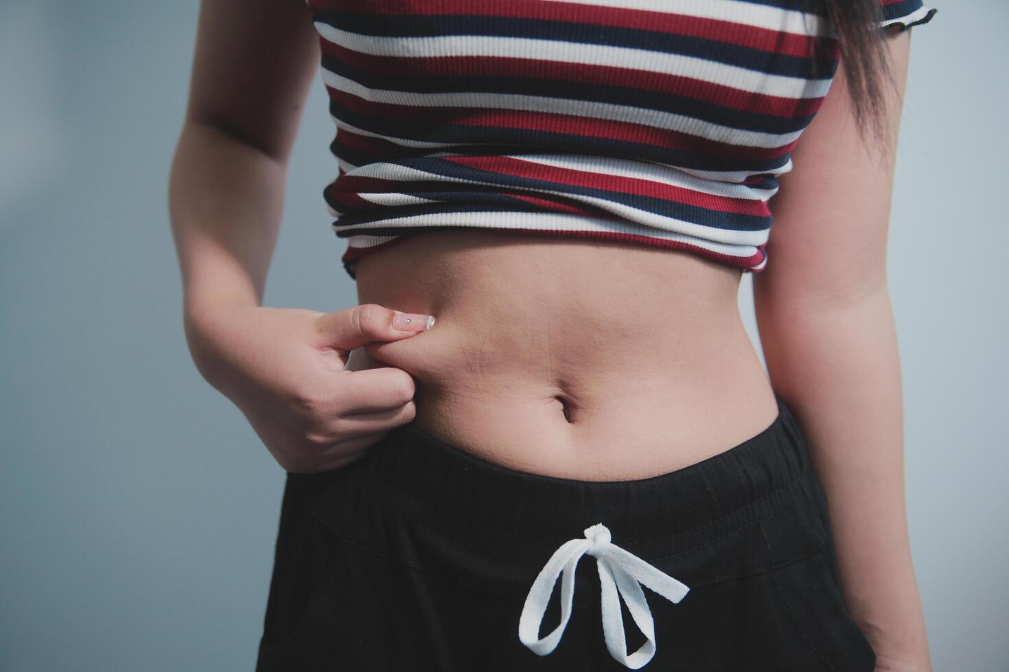 A woman with a small belly showing off her stomach photo