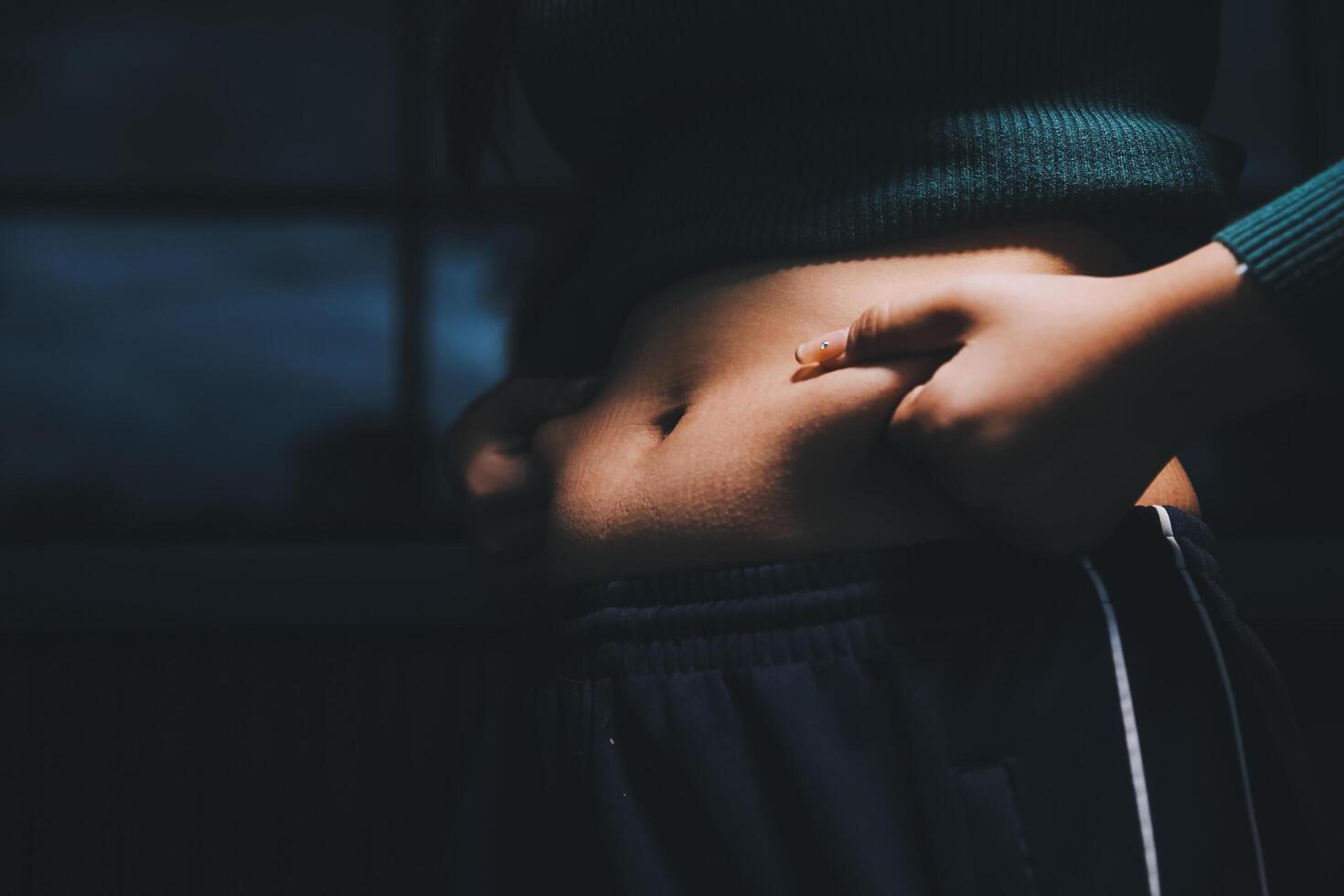 A woman with her hands on her stomach photo