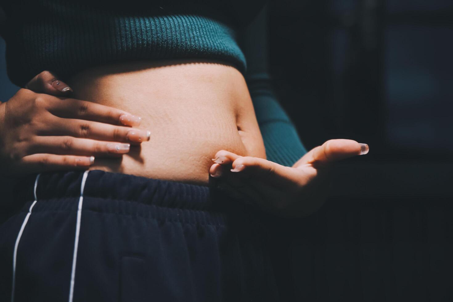 A woman is holding her stomach with her hands photo