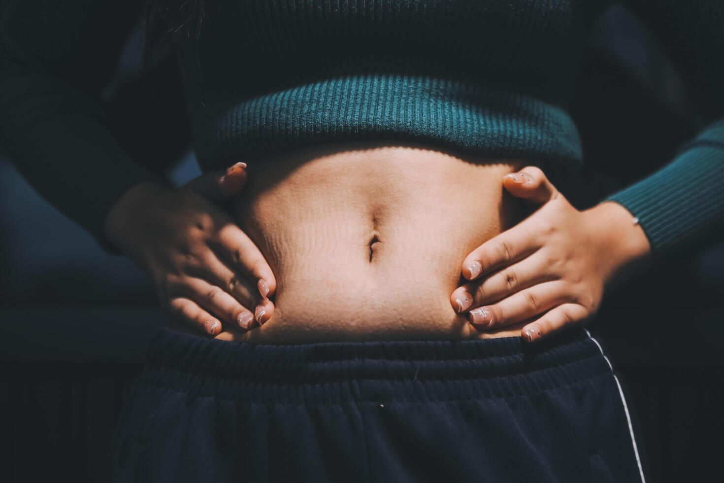 A woman with her hands on her stomach photo