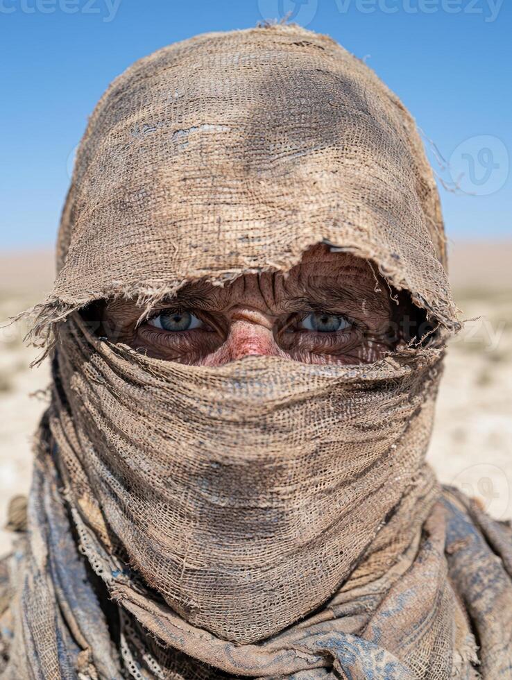 A weathered person wearing a traditional desert head covering photo
