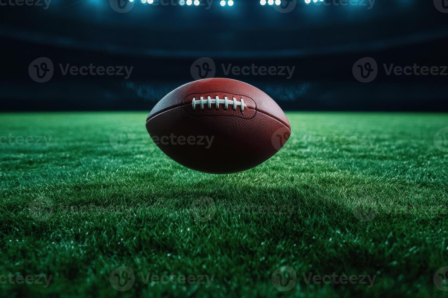 American football on a grass field under stadium lights photo