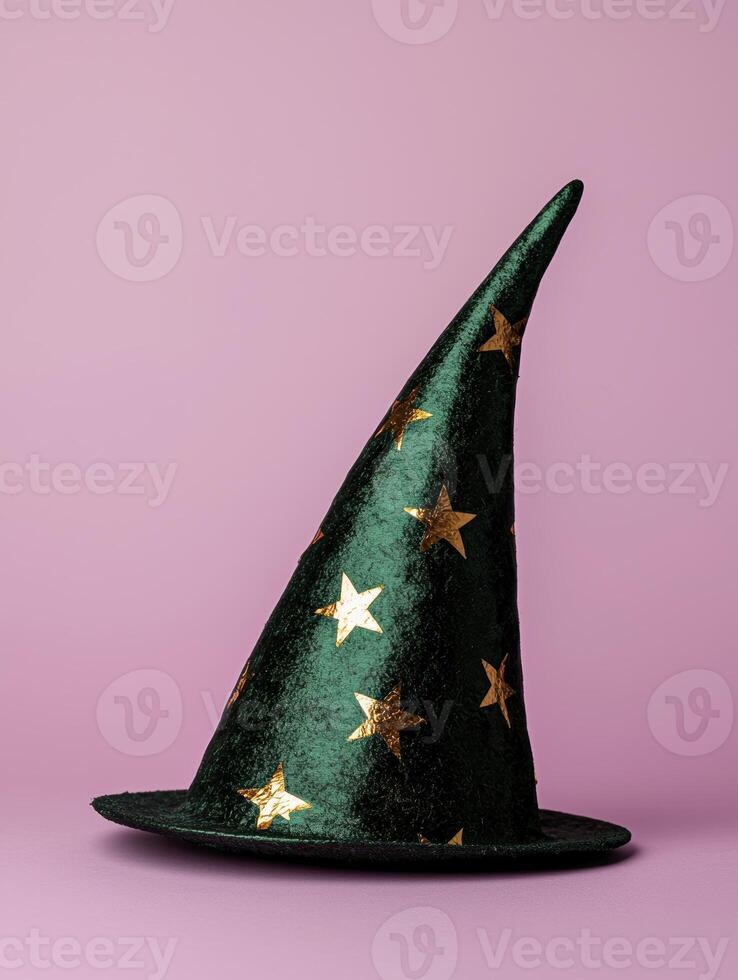 A green witch hat with gold stars on a pink background photo
