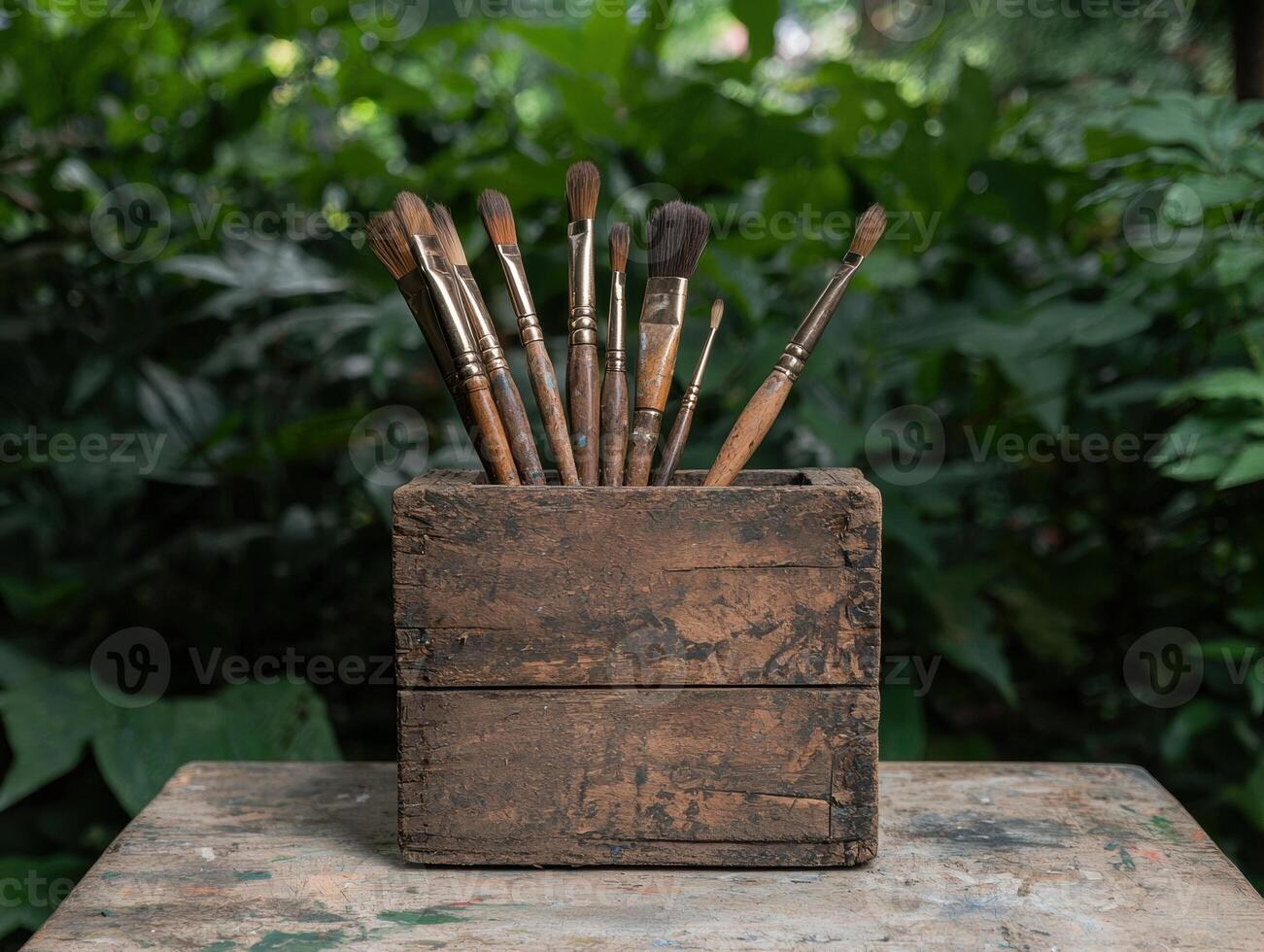 A collection of paintbrushes in a rustic wooden box photo