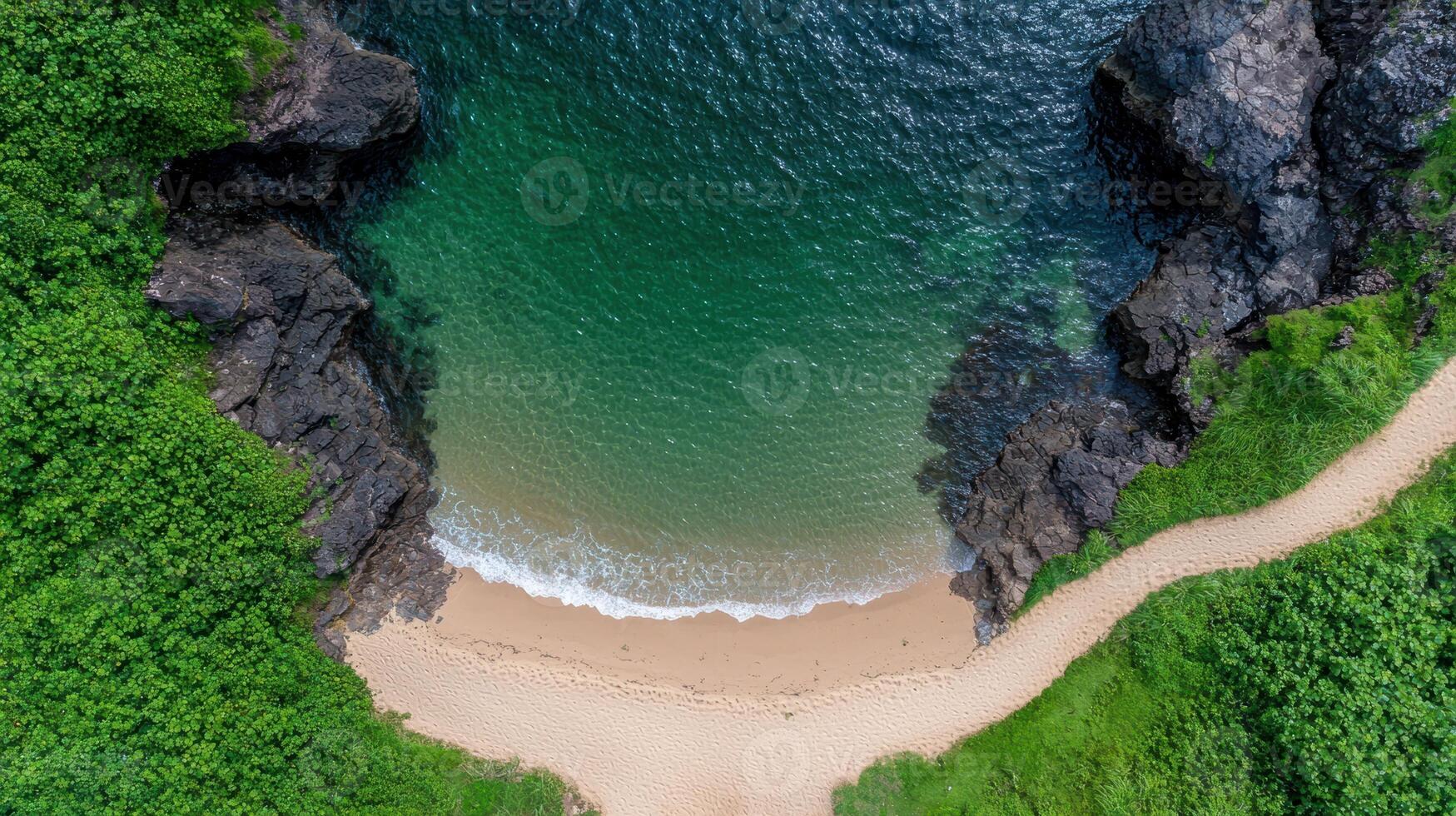 Aerial view of a secluded beach cove with turquoise water and lush greenery photo