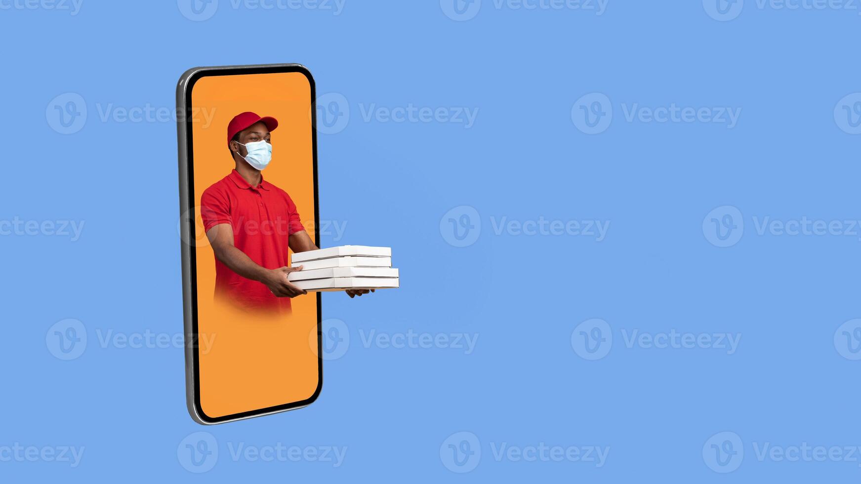 Black Deliveryman In Cellphone Giving Pizza Boxes To The Side Wearing Protective Face Mask Delivering Restaurant Food Over Yellow Studio Background. Panorama With Copy Space, Collage. Delivery App photo