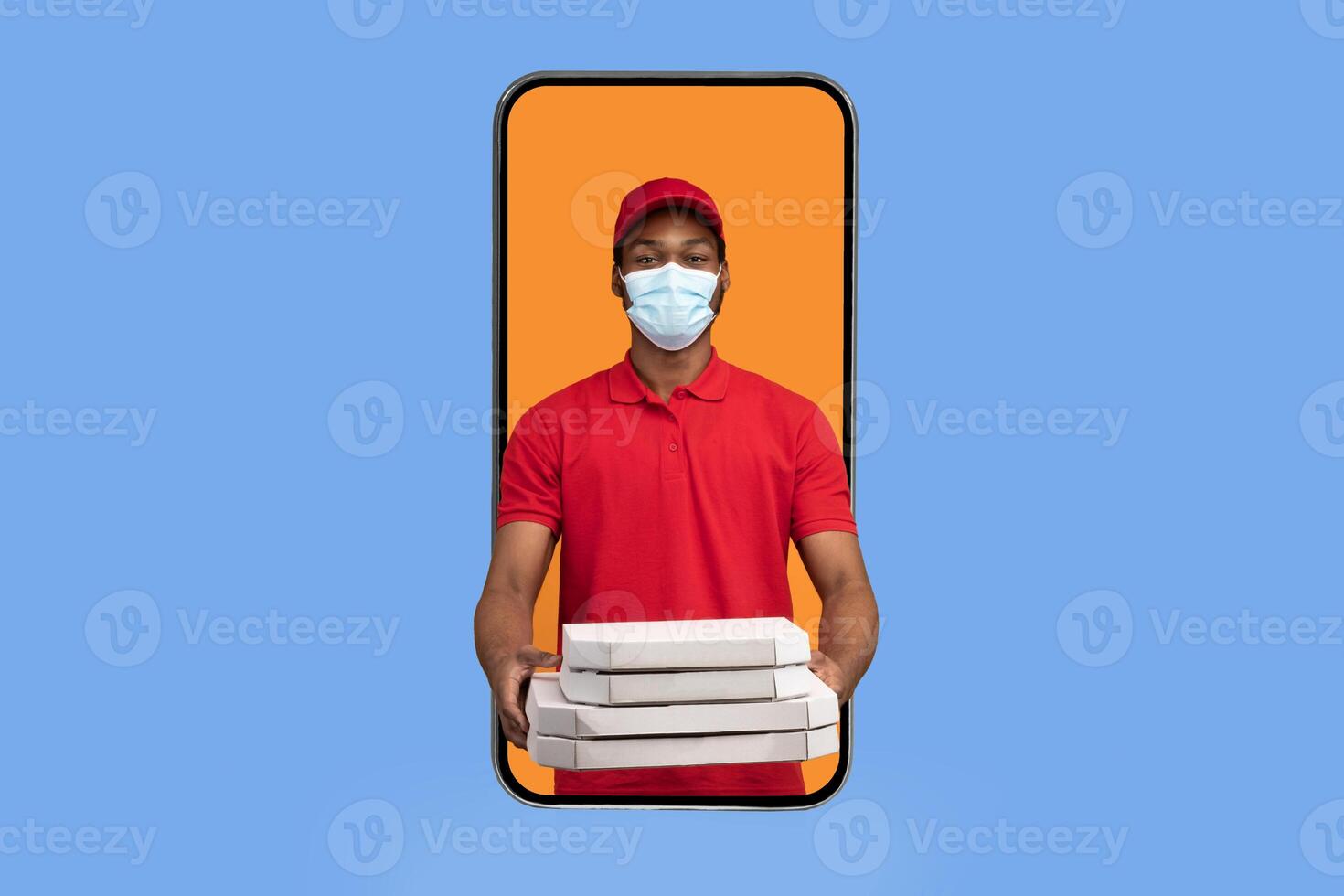 Food Delivery App. African american courier in mobile phone screen holding pizza boxes wearing face mask, delivering meal from restaurant and giving it to camera, yellow background. Square photo