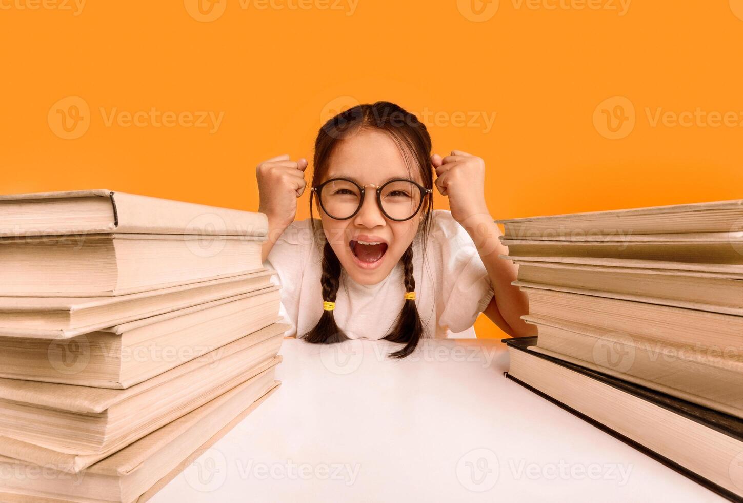 Emotional Asian Schoolgirl Shouting Crying Sitting At School Books Doing Homework On Yellow Studio Background. photo