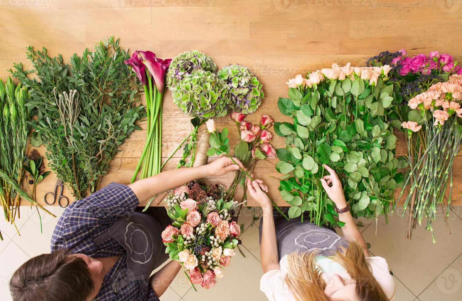Small business. Flowers delivery top view. Florists creating order, making rose bouquet in flower shop. photo