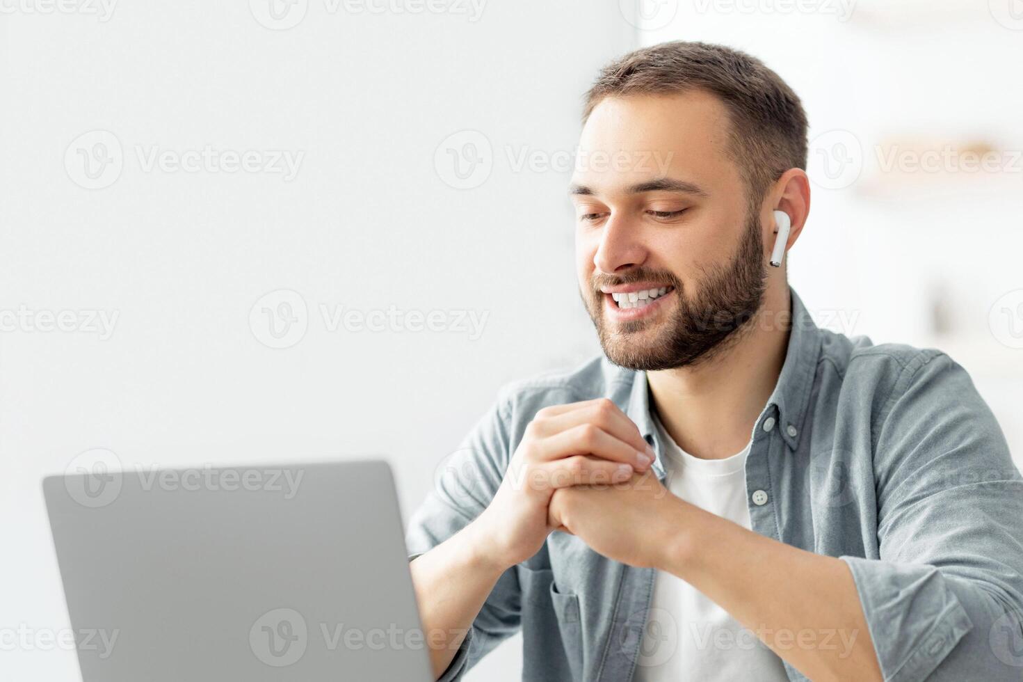 Happy male teacher giving English lesson on web using laptop at home office. Young tutor explaining grammar rules to students on web during covid quarantine. Modern remote education concept photo