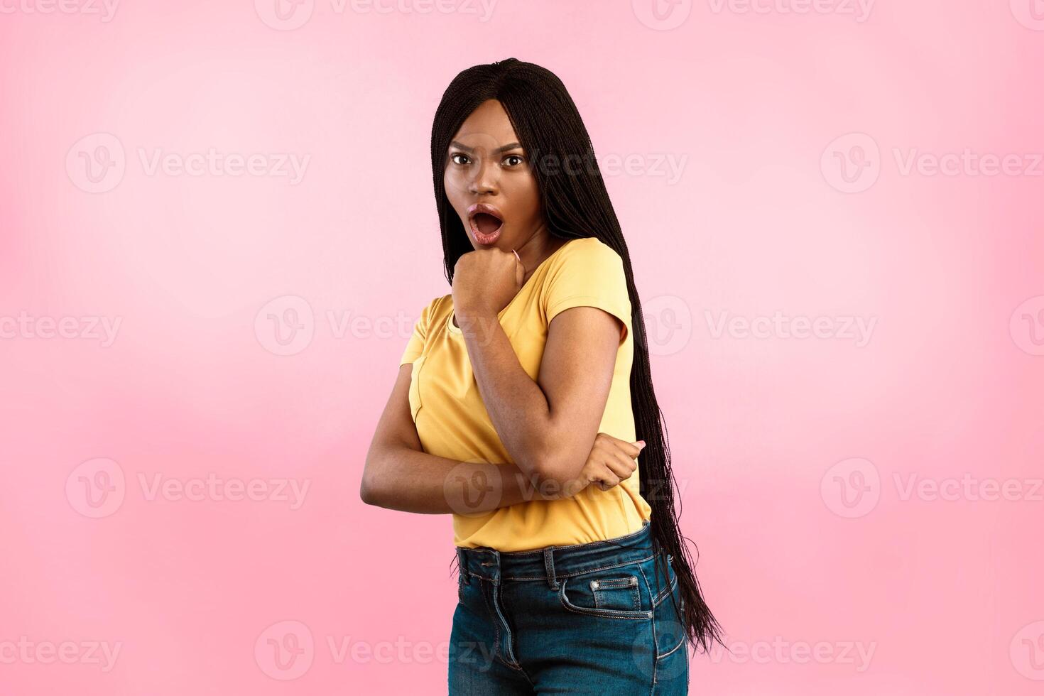 Shocked African American Lady Posing With Opened Mouth Holding Chin With Her Fist Expressing Surprised Emotion Standing Over Blue Background. Studio Shot. Human Emotions And Expressions photo