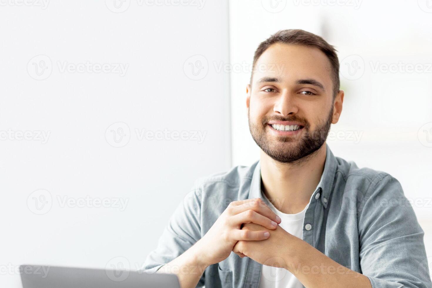 Positive male teacher giving English lesson online, using laptop at home office. Young Caucasian tutor explaining grammar rules to students on web indoors. Modern remote education concept photo