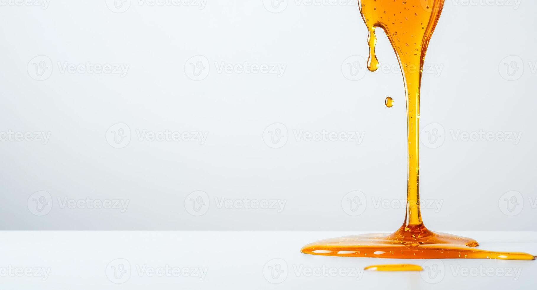 Warm golden honey flows and splashes onto a clean white surface, creating beautiful liquid shapes. The sunlit background enhances the vibrant color, highlighting its smooth texture. photo