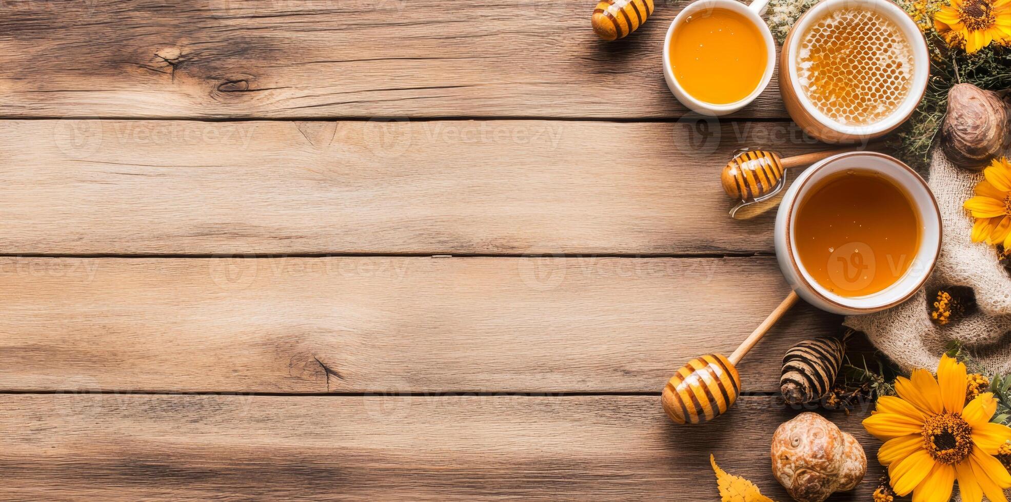 A lovely arrangement features honey in bowls, a honey dipper, and delicate flowers on a rustic wooden table. Natural elements enhance the warm ambiance, inviting a sense of comfort and sweetness. photo