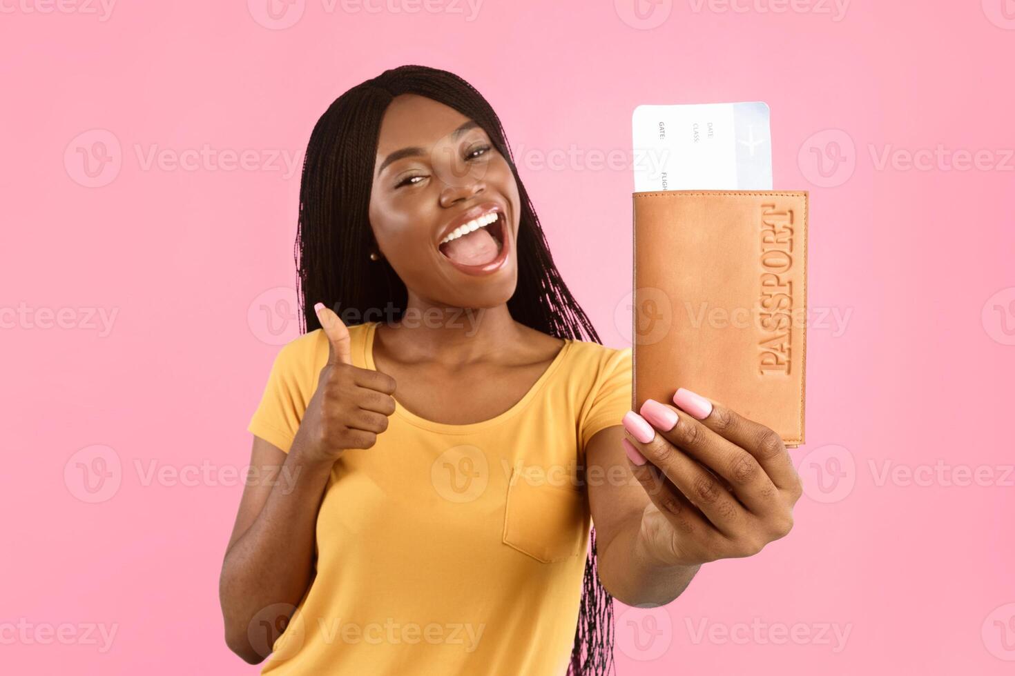 Vacation, Finally. Happy African American Female Showing Travel Tickets And Passport Gesturing Thumbs Up Posing On Blue Background In Studio. Selective Focus On Boarding Pass. Traveling And Tourism photo
