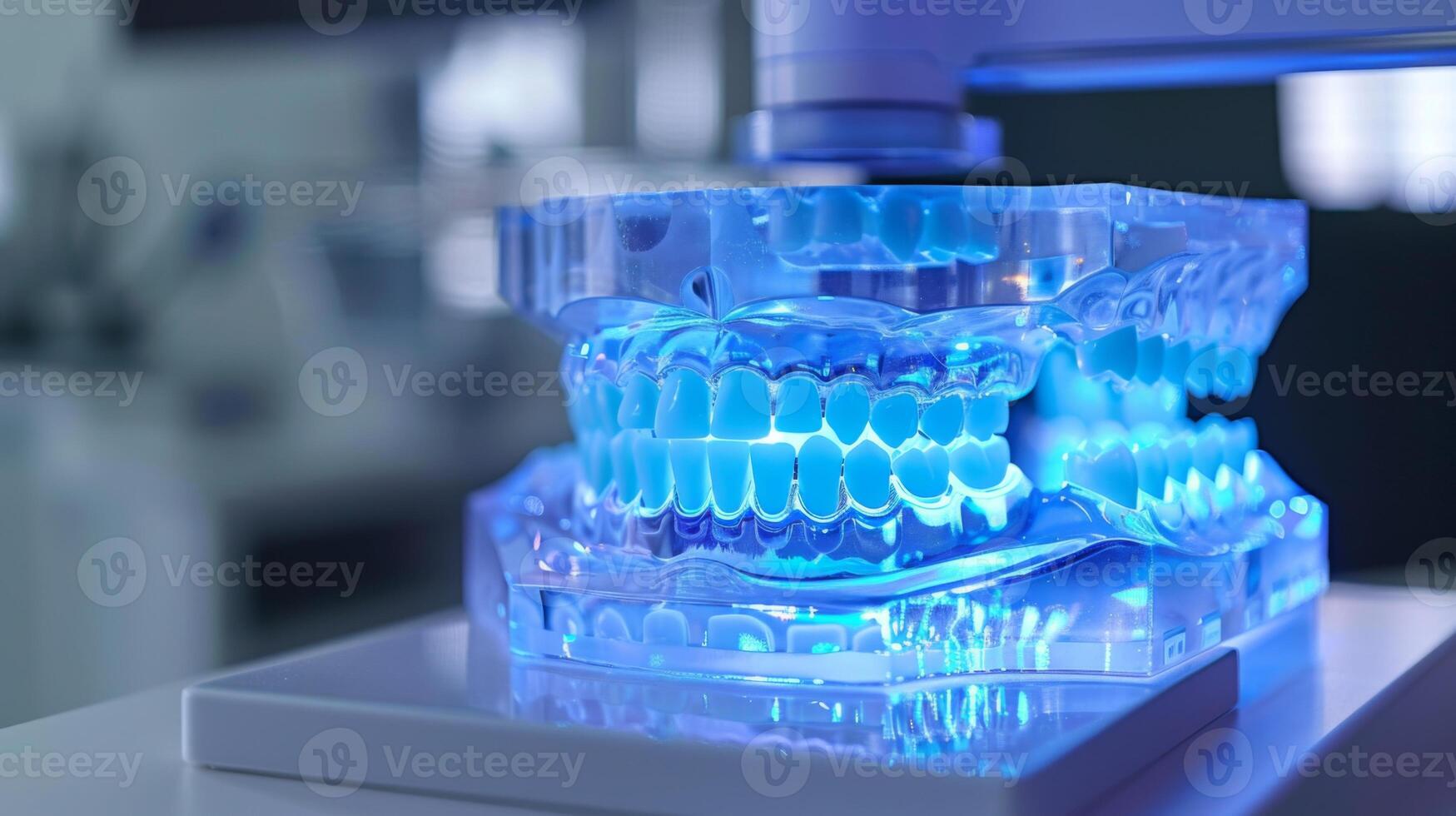 A 3D printer is actively creating a transparent mold of teeth in a contemporary dental laboratory. Blue light illuminates the mold during the printing process, showcasing cutting edge technology. photo