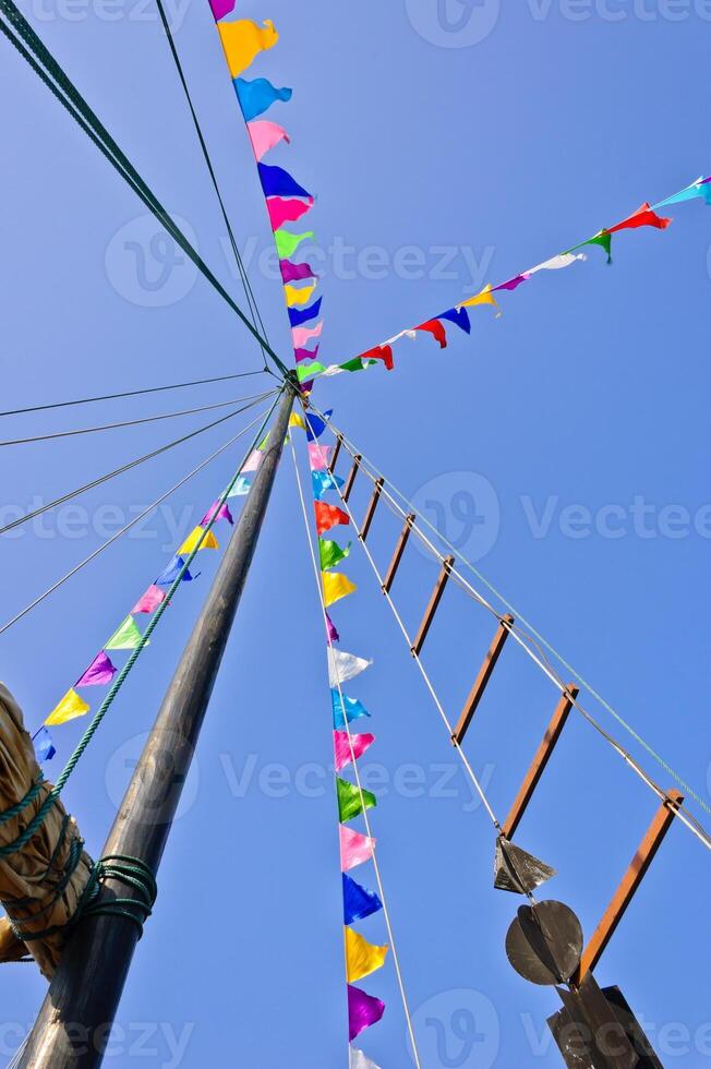 Mast and sail rolled-up with colorful flag photo