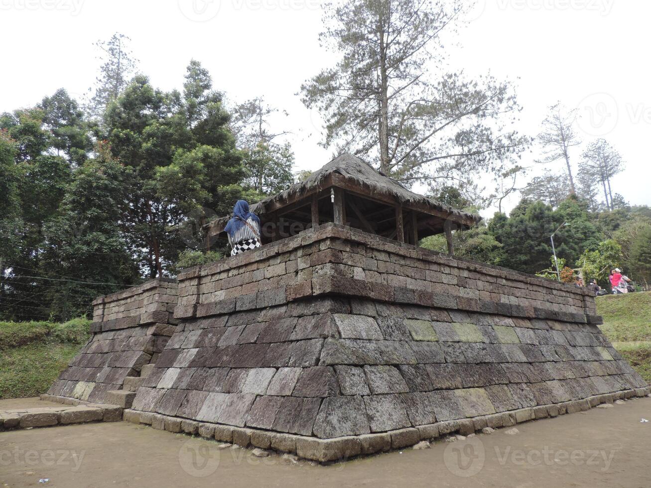 a small temple with a roof on top of a hill photo