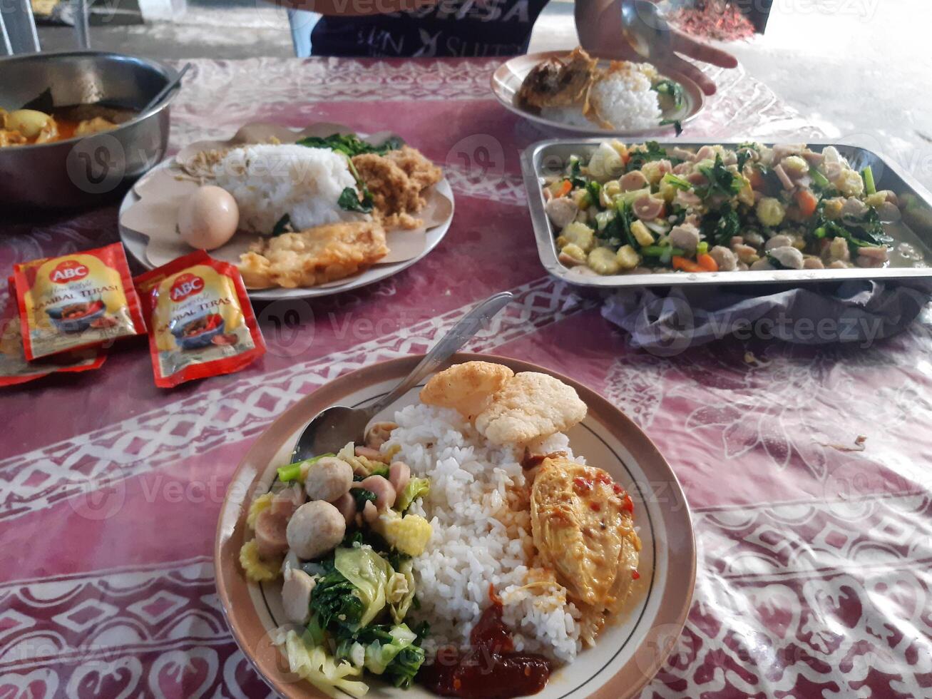 a table with food on it and a person eating photo