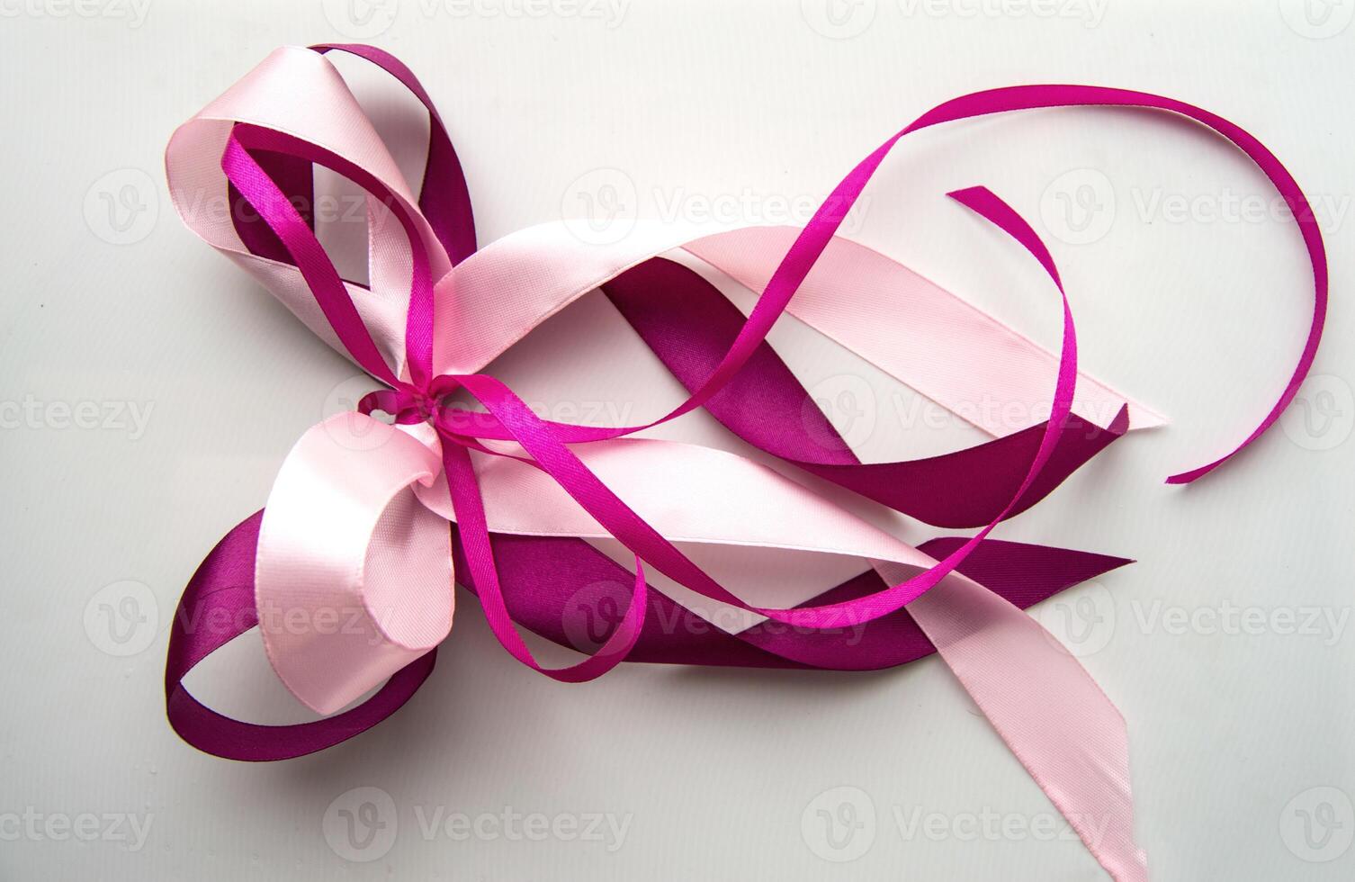 A pink ribbon with a bow tied to it photo