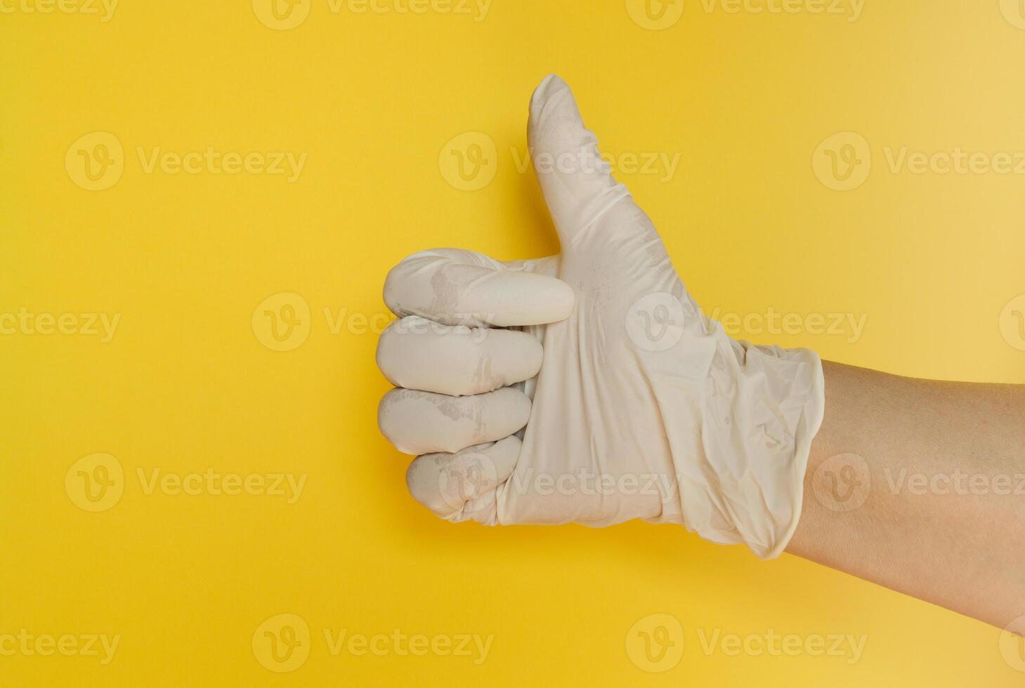 A person in a white glove giving the thumbs up photo