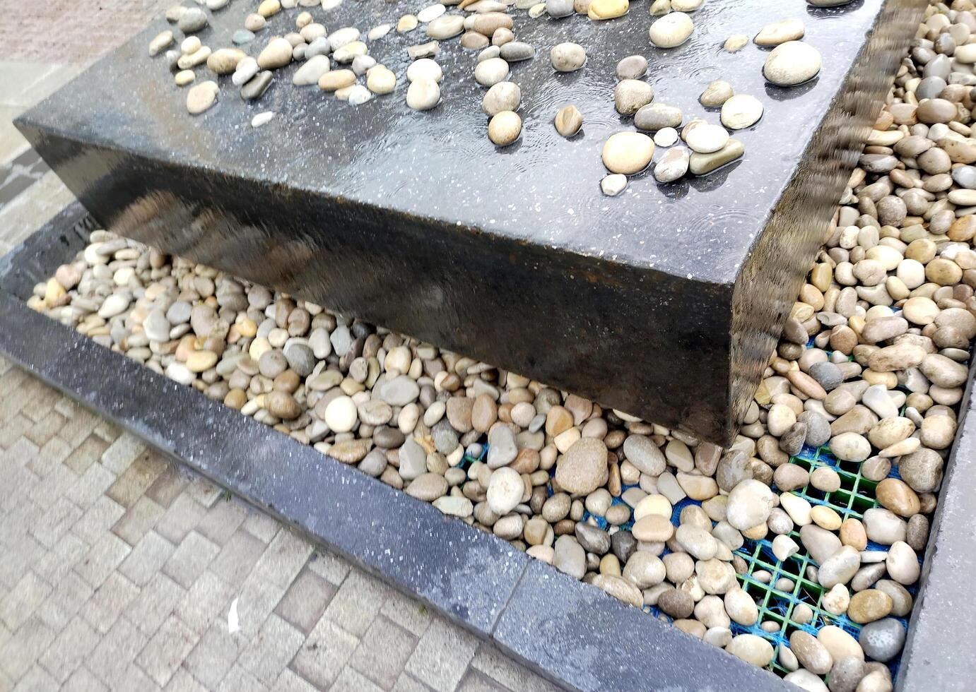 A large black stone slab with pebbles on it photo