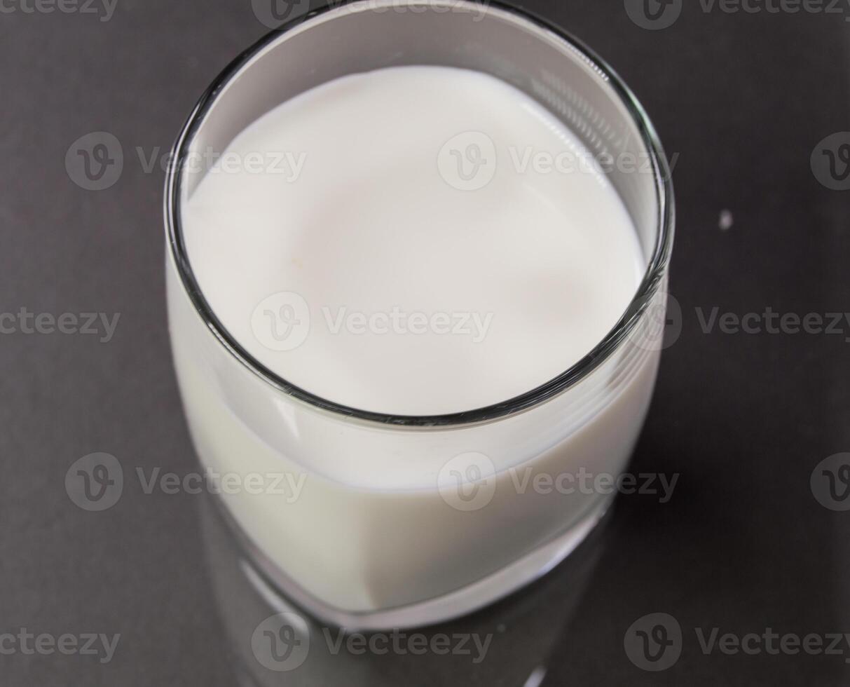 A glass of milk on a black surface photo