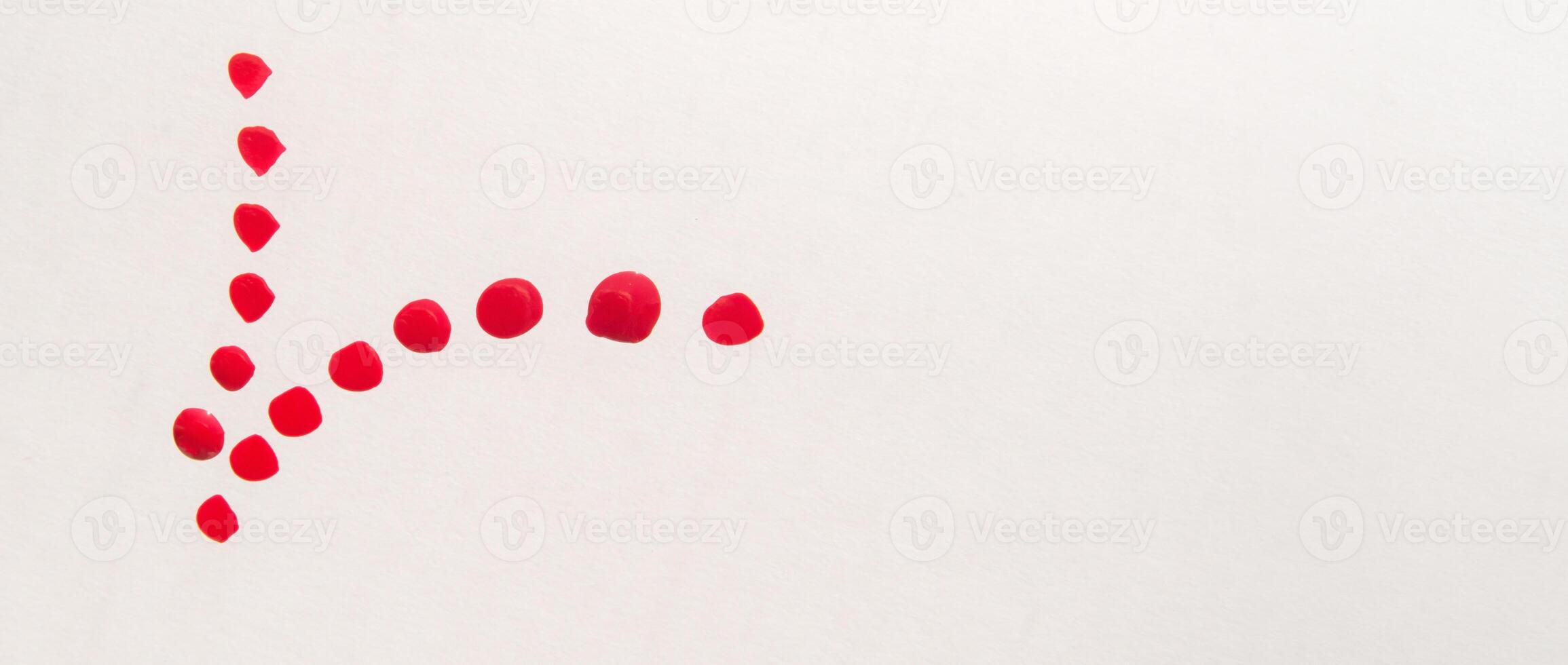 A red dot is drawn on a white surface photo